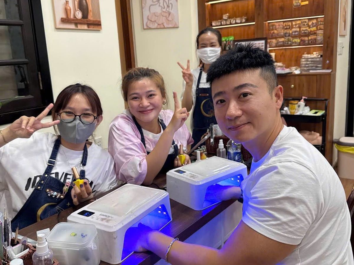 Khách nam hơ móng gel dưới đèn UV cùng các kỹ thuật viên Fleur